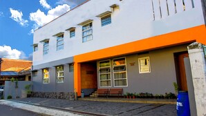 A modern building with a flat roof, multiple windows, and a bench outside. - Saidah Guest House (Bandung)
