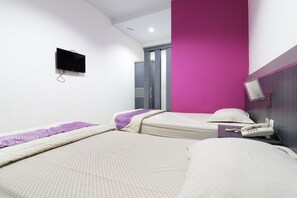 A hotel room with two beds, a flat-screen TV mounted on the wall, a telephone on the nightstand, and a mirror on the wall. - Hasanah Guest House (Pekanbaru)