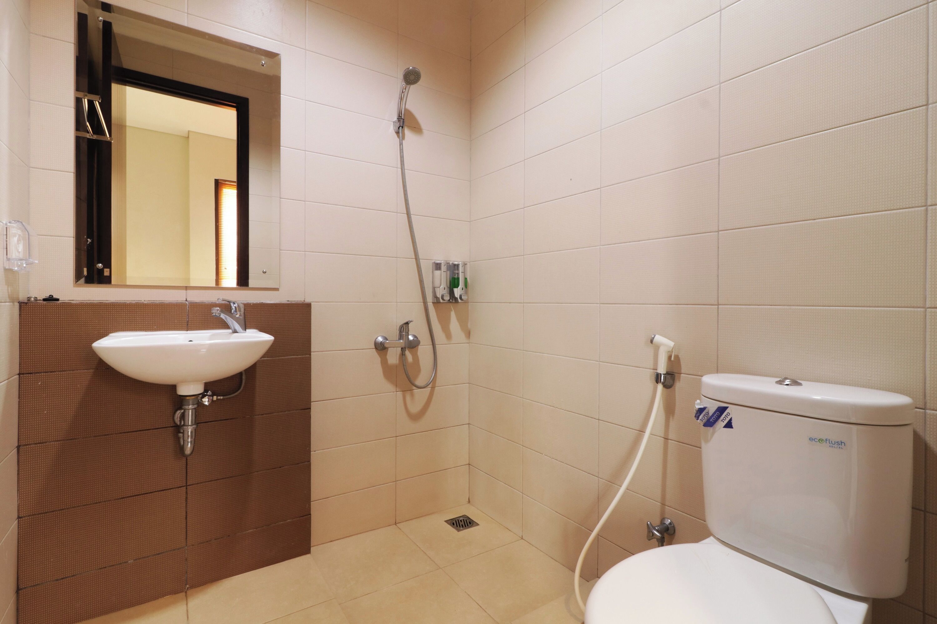 A bathroom with a sink, mirror, shower, and toilet.