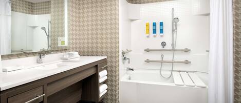 Une salle de bain moderne avec un meuble-lavabo à deux vasques, une baignoire et une douche.