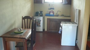 Una cocina compacta con una mesa, sillas, refrigerador, estufa y lavaplatos.