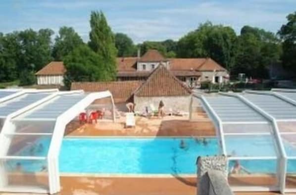 Piscine extérieure en saison, parasols, chaises longues