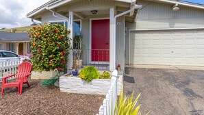 A house with a red door, a garage, and a driveway. - Beach cottages, majestic Morro Bay (Morro Bay)