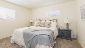 A bedroom with a bed, bedside tables, and a nightstand. - Beach cottages, majestic Morro Bay (Morro Bay)