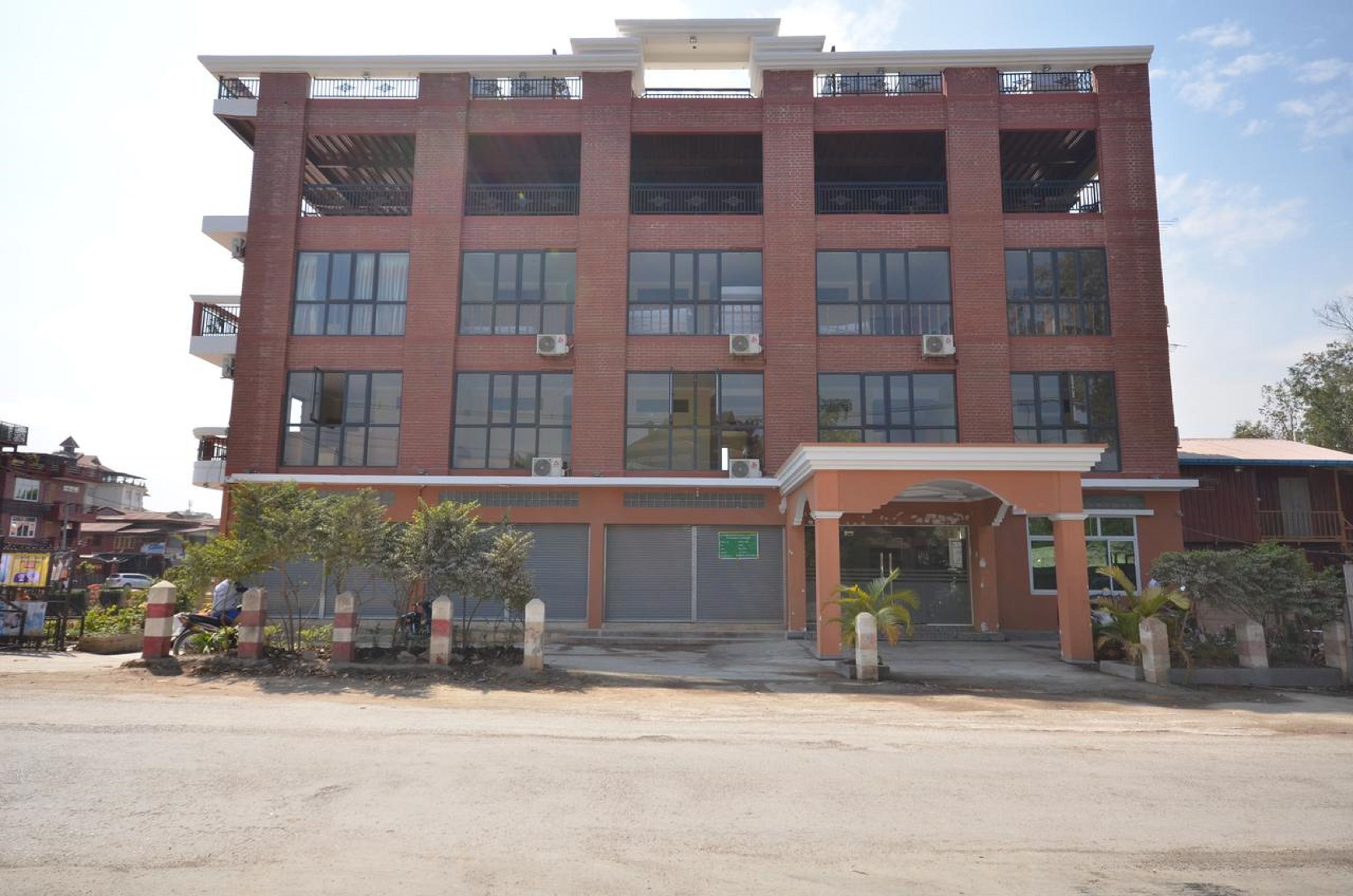 A multi-story building with a brick facade, large windows, and a central entrance.