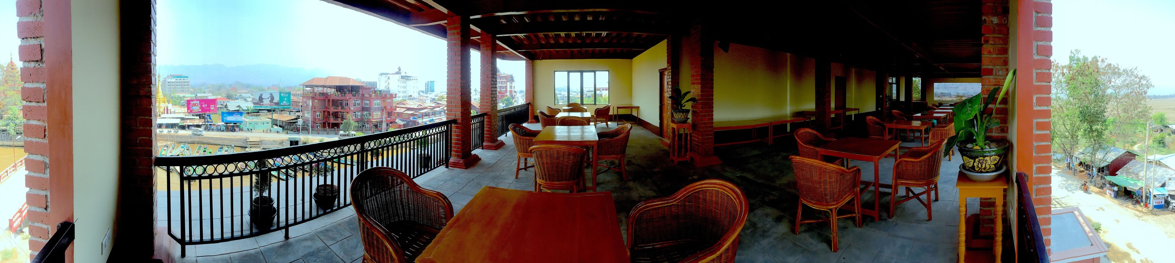 A restaurant with outdoor seating, brick walls, and a view of the cityscape.
