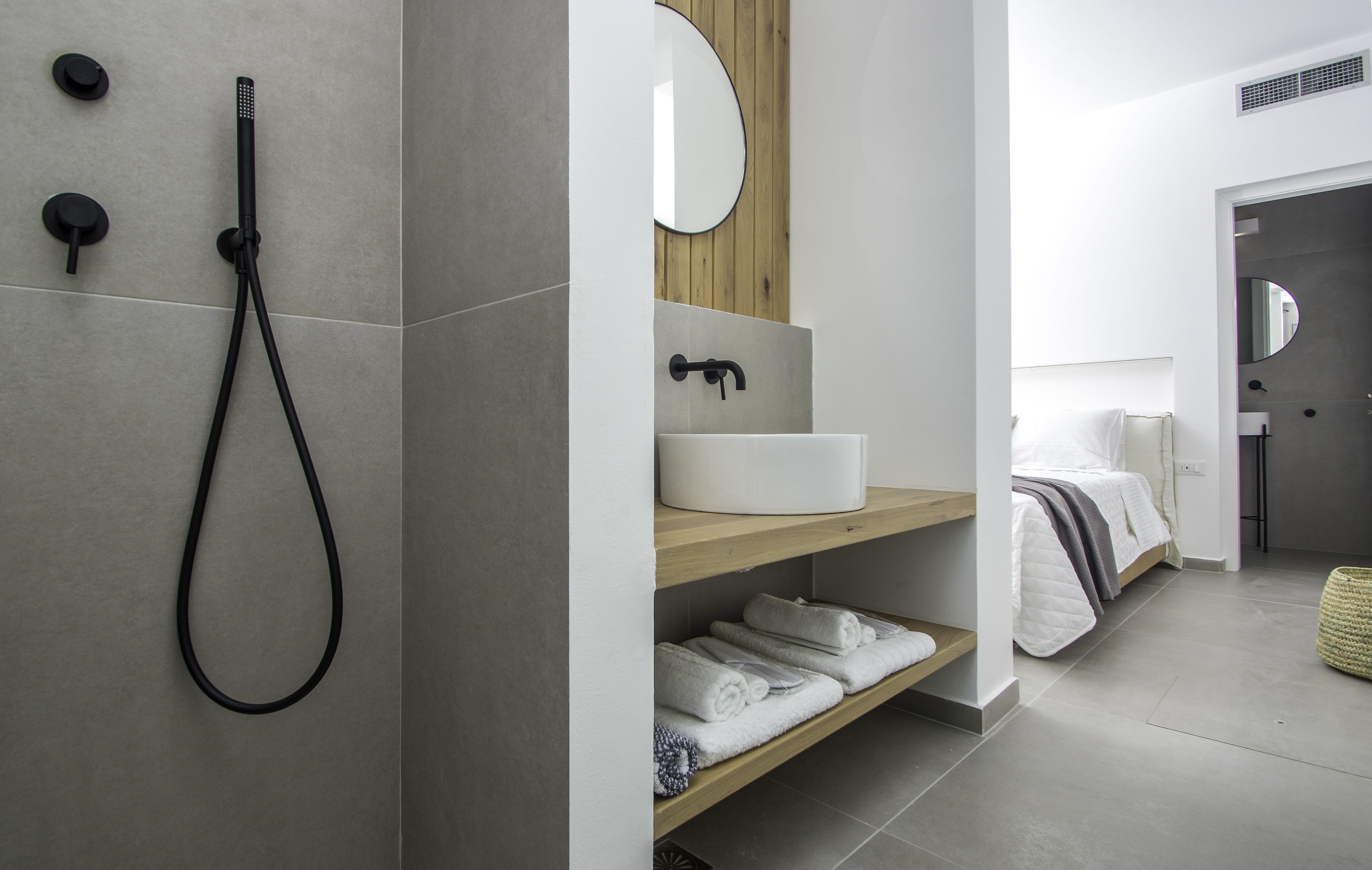 Un bagno moderno con doccia, lavandino e specchio.