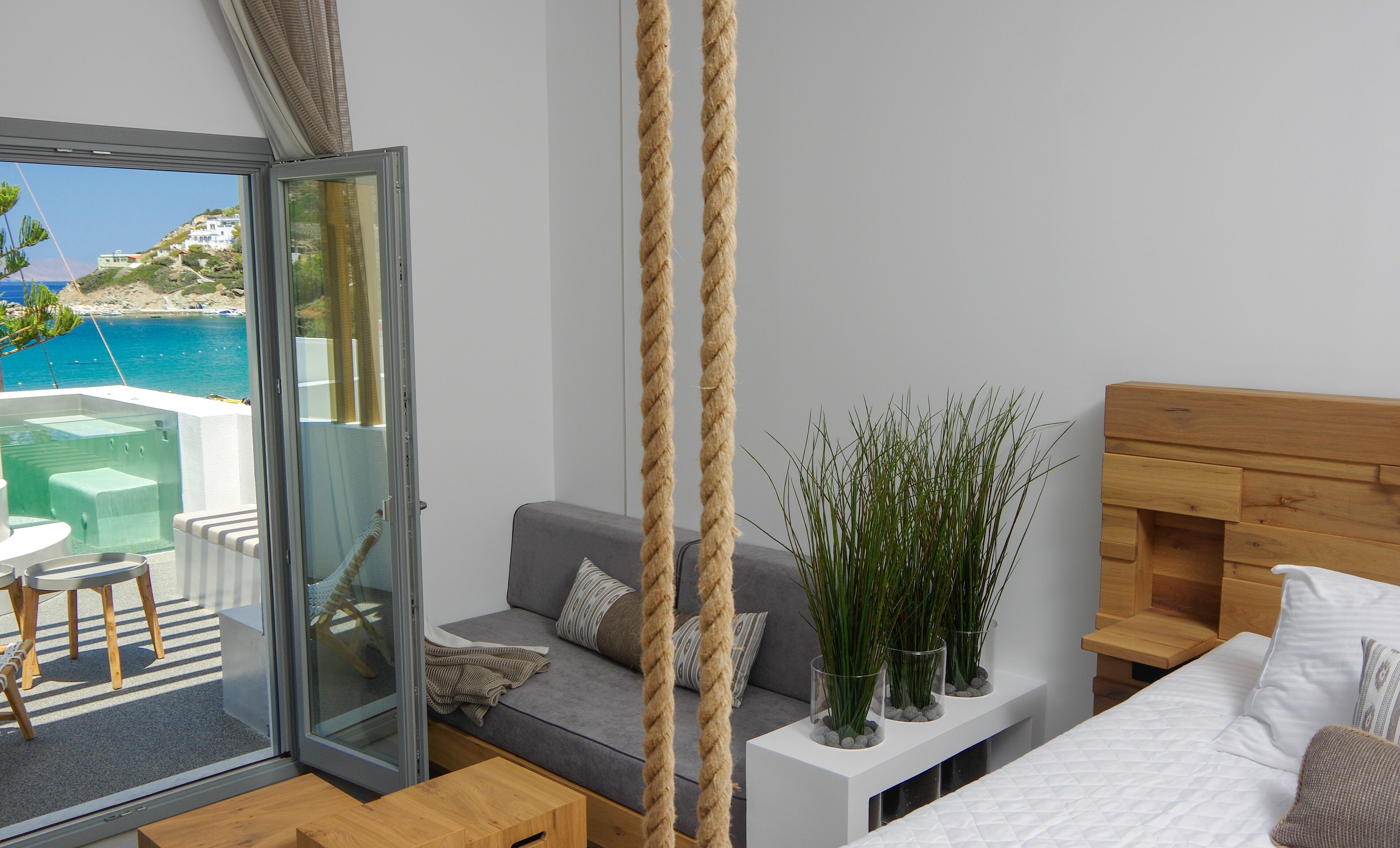 Une chambre moderne avec une porte vitrée donnant sur un balcon qui offre une vue sur la plage.