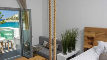 Une chambre moderne avec une porte vitrée donnant sur un balcon qui offre une vue sur la plage.