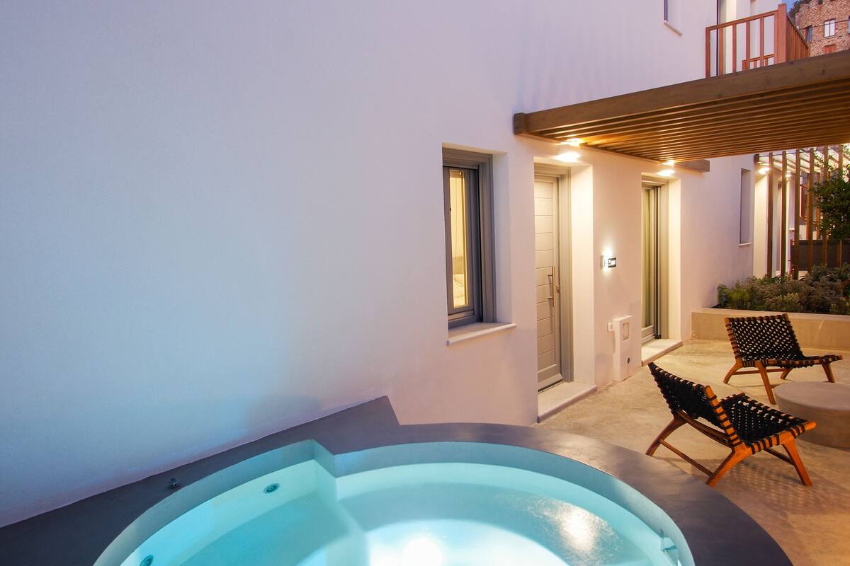 A modern outdoor pool area with a curved design, a covered seating area, and a well-lit entrance.