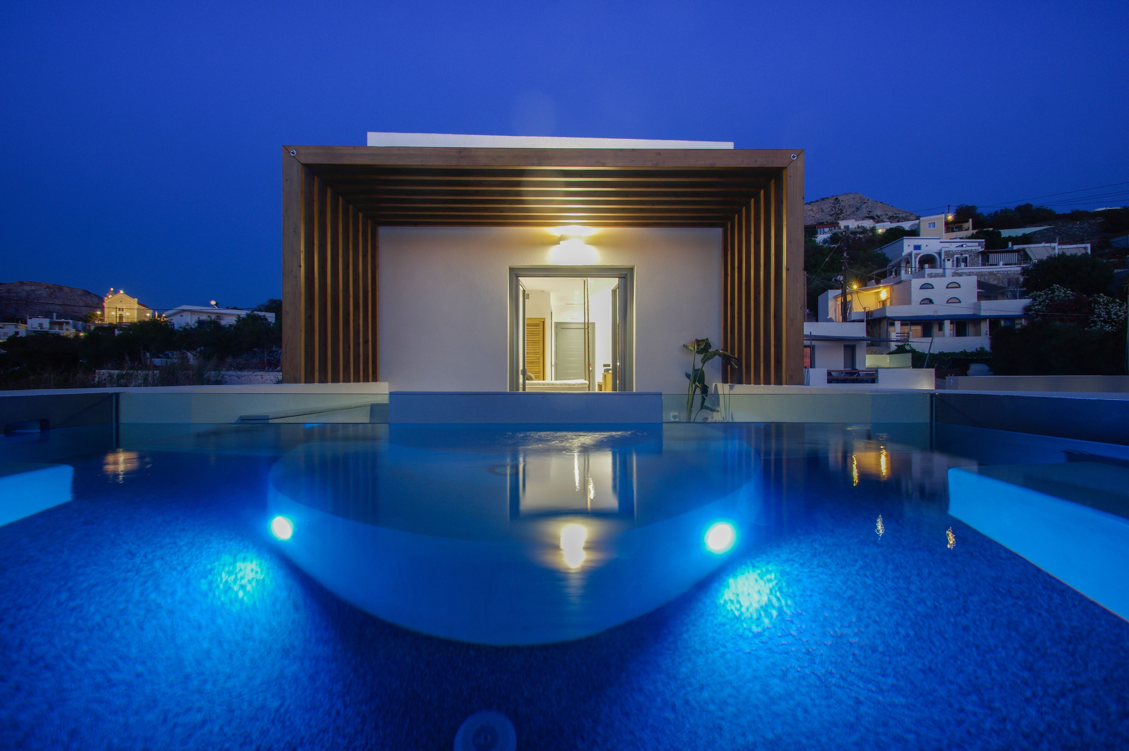 A modern building with a swimming pool in front.