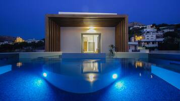 A modern building with a swimming pool in front.