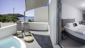 A balcony with a pool, a bed, and a view of the sea. - Oro Suites (Syros)