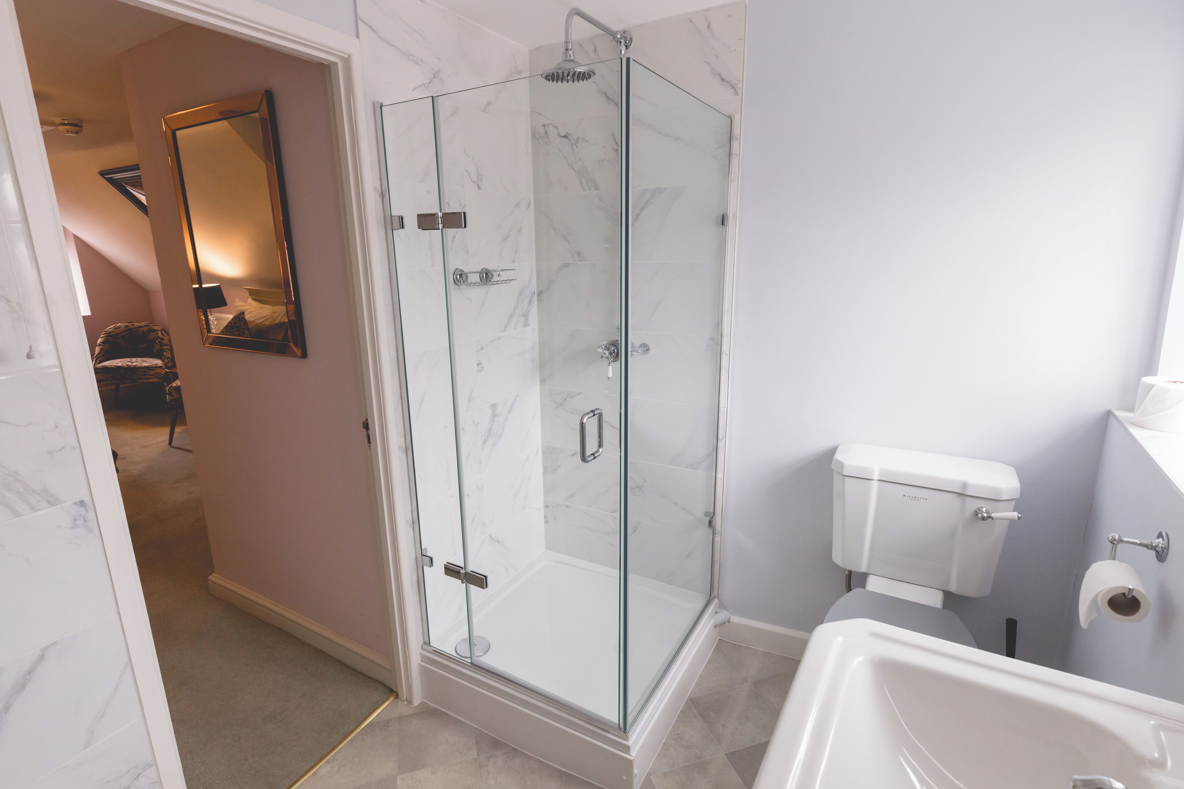 Un bagno moderno con doccia vetrata, un water bianco e una vasca da bagno.