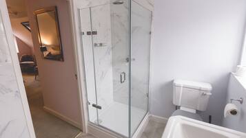 Un bagno moderno con doccia vetrata, un water bianco e una vasca da bagno.