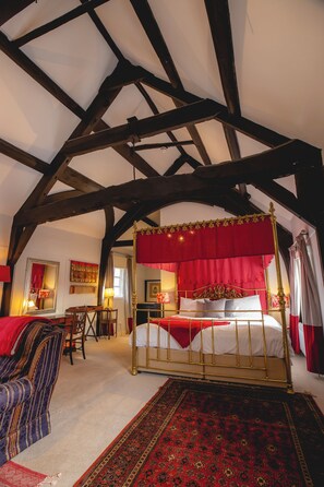 A bedroom with a four-poster bed, a red canopy, a wooden ceiling, and a patterned carpet. - The Old Vicarage (Bridgwater)