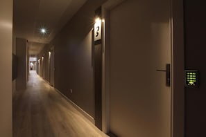 A hotel corridor with doors numbered, a hallway, and a door with a keypad lock. - Eibarrooms (Eibar)