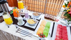 A buffet table with various food items and beverages.