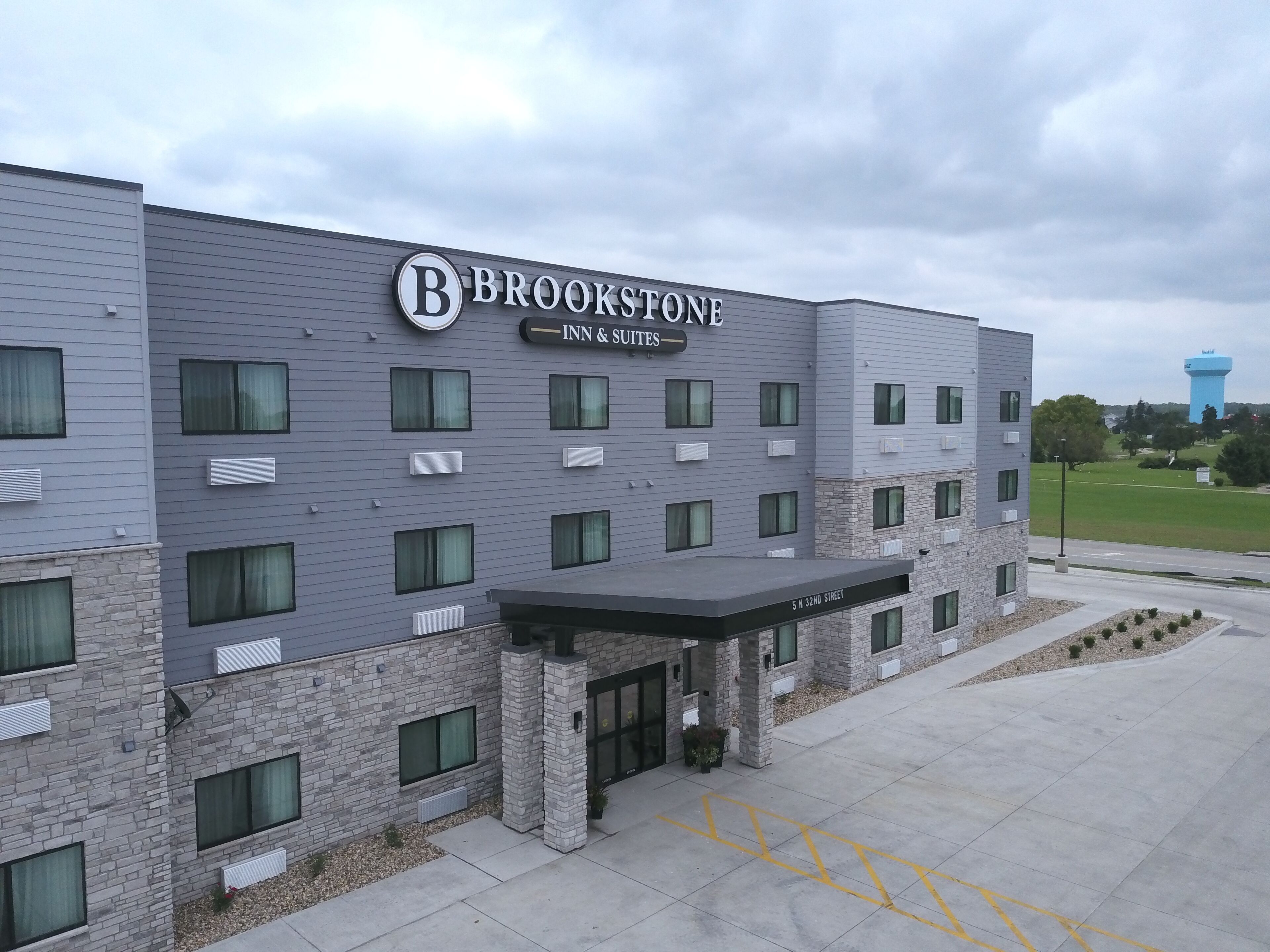 A modern building with a sign reading "Brookstone Inn & Suites."
