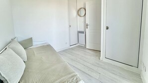 Un dormitorio con cama, armario y puerta.