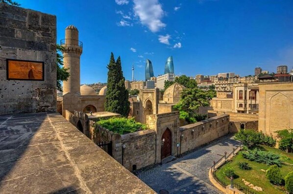 A historical site with ancient architecture, including a tower and domed structures.