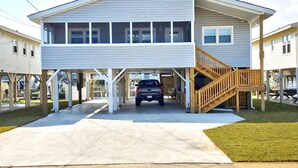A two-story house with a covered garage and a wooden staircase.