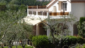 Un edificio a due piani con facciata bianca e tetto in tegole rosse.