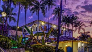 A large, multi-story house with a well-lit entrance and a stone staircase leading up to the main door. - Confraria Colonial Hotel Boutique (Mairinque)