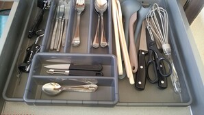 A drawer with utensils and kitchen tools, including forks, spoons, knives, and a whisk. - Spacious and cozy studio with breathtaking views (Saint-Mandrier-sur-Mer)