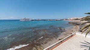 A cruise ship docked at a beach with clear blue water and a sandy shore. - Cristianmar (Los Cristianos)