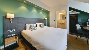 A modern hotel room with a large bed, bedside tables, a wardrobe, and a dining area. - Kyriad Crepy en Valois (Crepy-en-Valois)