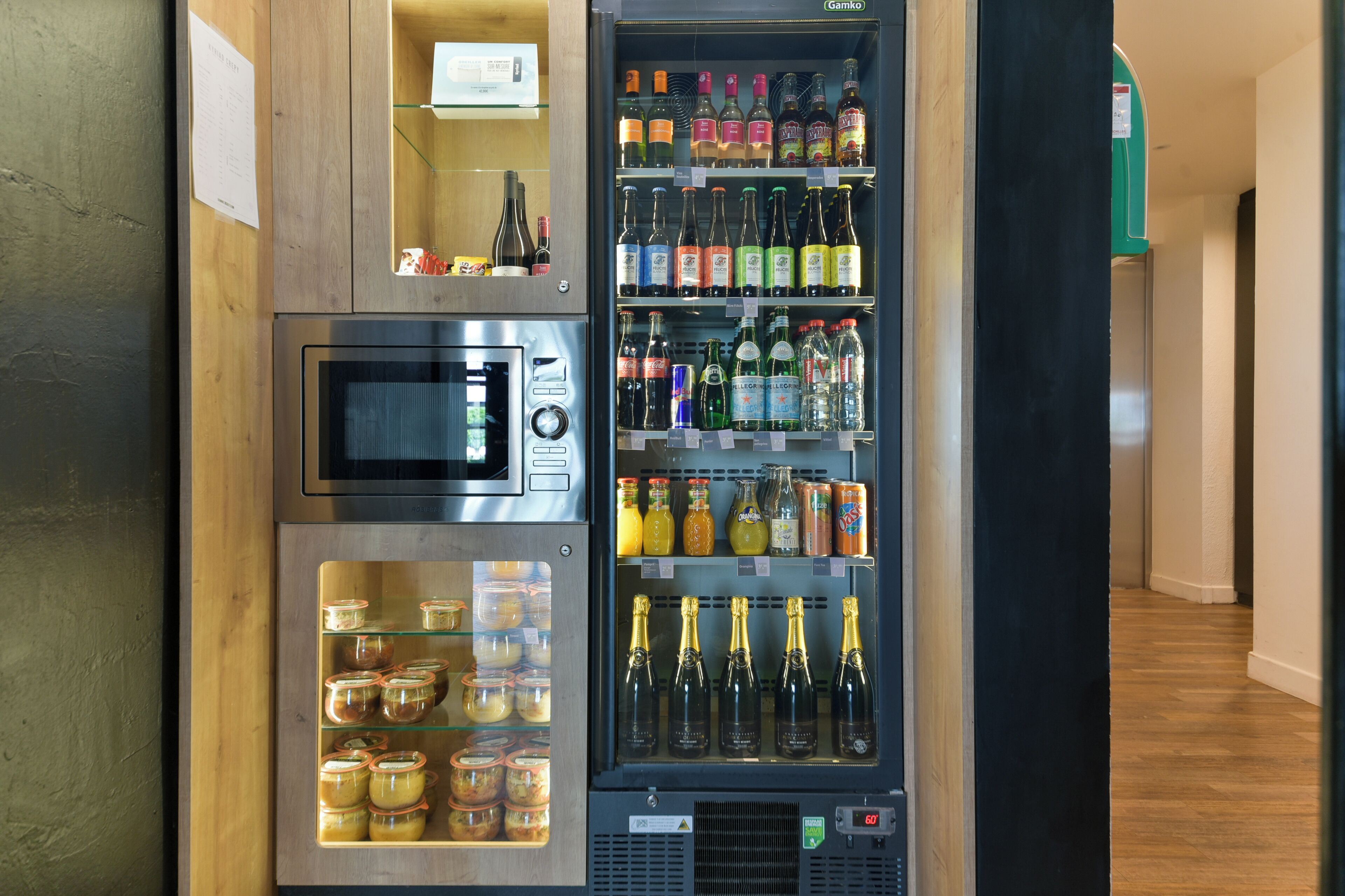 Una macchina distributrice automatica con forno a microonde e un reparto refrigerato contenente diverse bevande e condimenti.