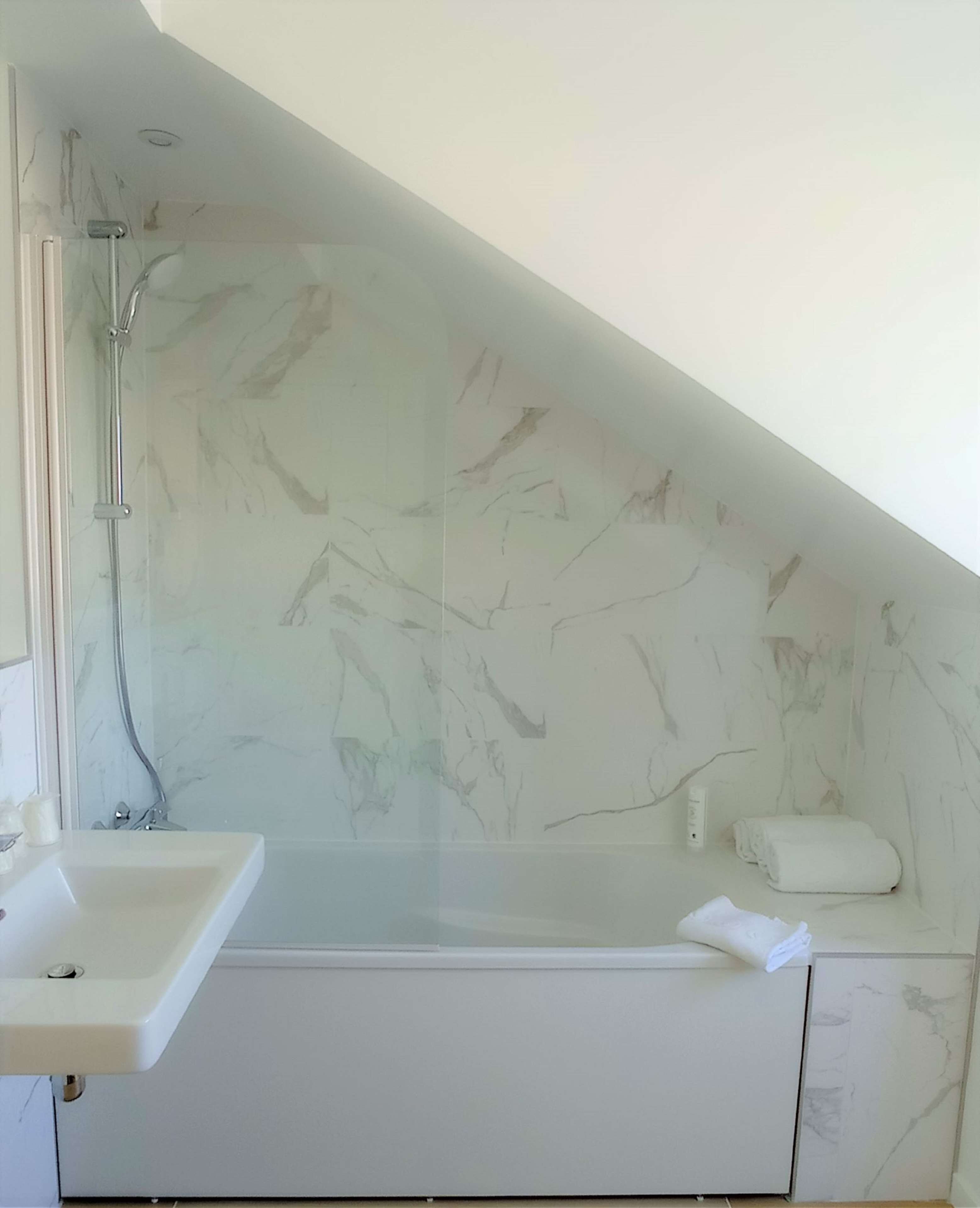 Ein Badezimmer mit Waschbecken, Dusche und Handtuchhalter.