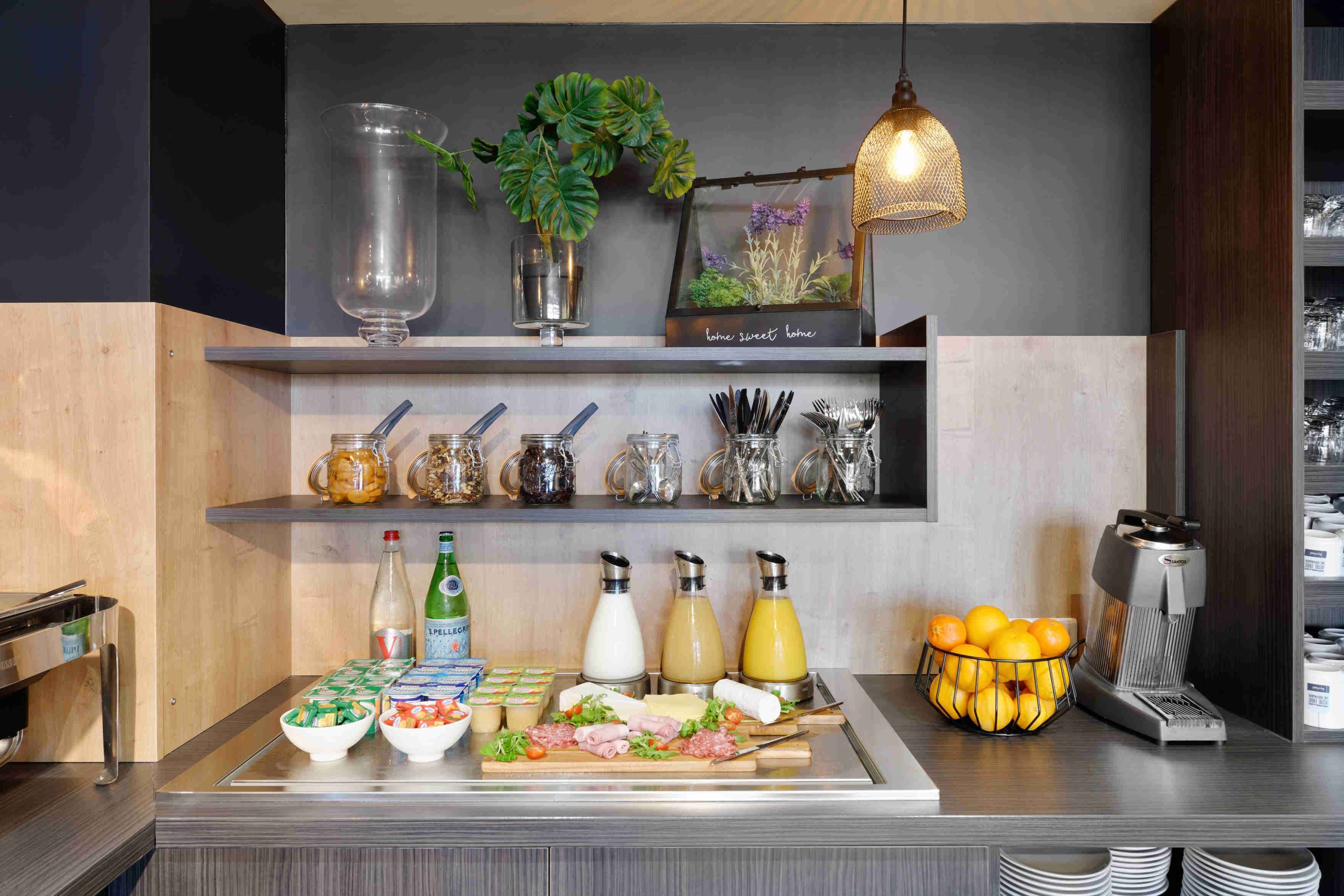 A breakfast bar with various food items, condiments, and a coffee machine.