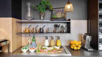 A breakfast bar with various food items, condiments, and a coffee machine.