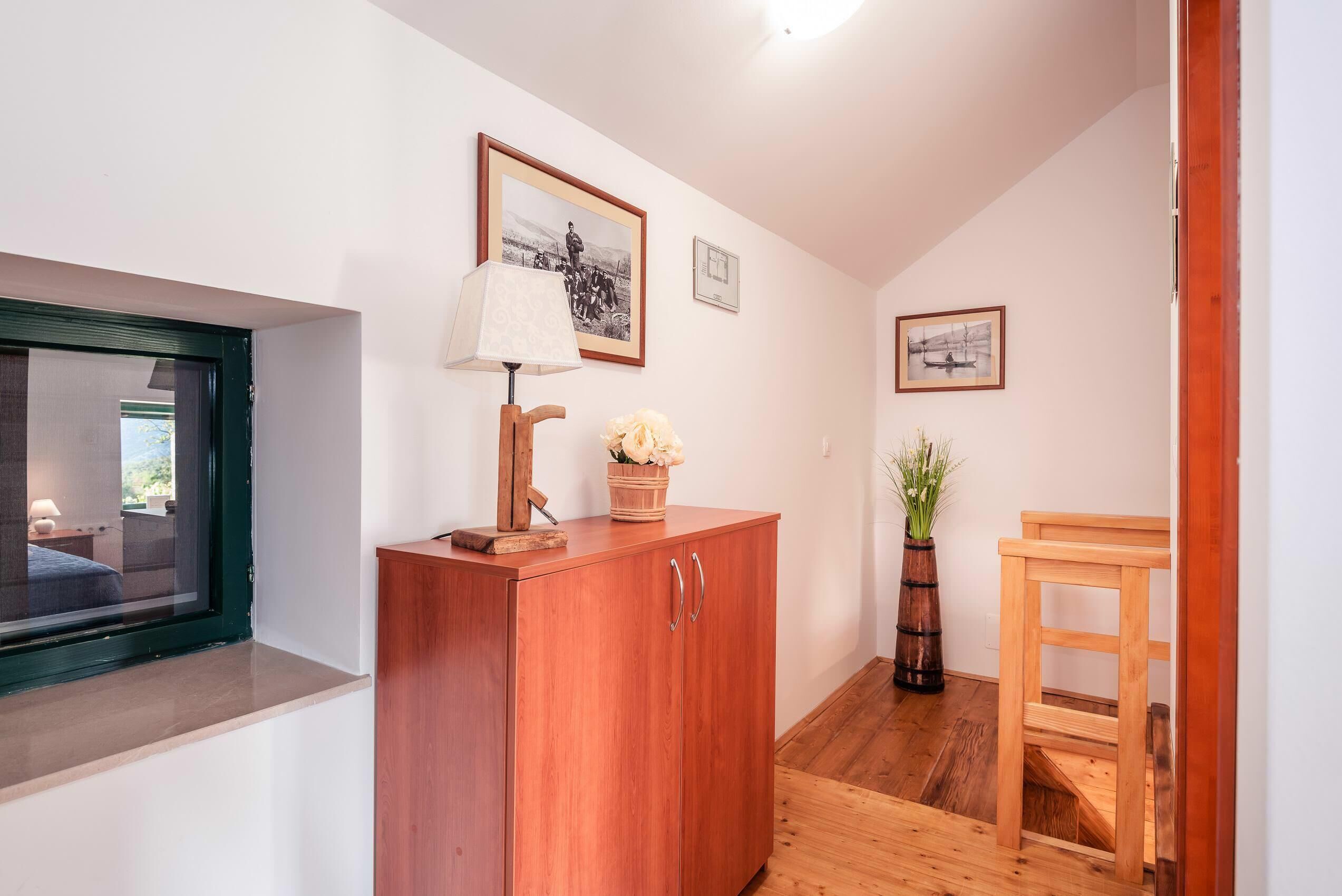 Un couloir avec une armoire en bois, une table et une fenêtre.