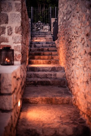 A stone staircase leading up to a gated entrance, surrounded by stone walls. - Getaway in the relaxing nature (Vid)