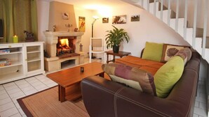 A cozy living room with a fireplace, a sofa, a coffee table, and a staircase. - Independent house with garden at equestrian, pets allowed (Montabard)