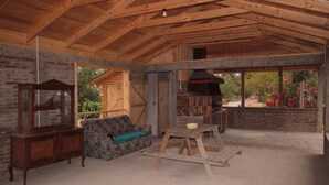 Un interior rústico con vigas de madera a la vista, una mesa de madera, un sofá y una chimenea.