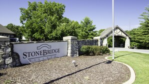 A stone bridge entrance with a sign reading "Stonebridge Village". - Stonebridge Condo and Golf Resort (Branson West)