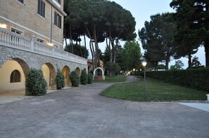 A paved pathway leading to a building with arched windows and a stone facade. - Villamaria Park Hotel (Albano Laziale)