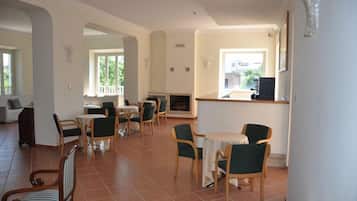 A spacious living area with a fireplace, multiple seating arrangements, and a balcony.