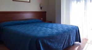 A single bed with a wooden headboard, a nightstand, and a wall-mounted lamp. - Villamaria Park Hotel (Albano Laziale)