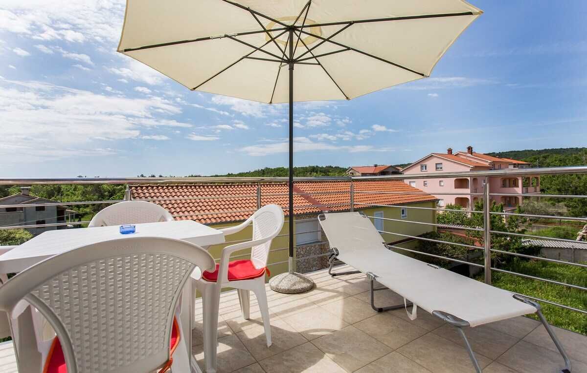Een terras met een tafel, stoelen, een bank en een parasol.