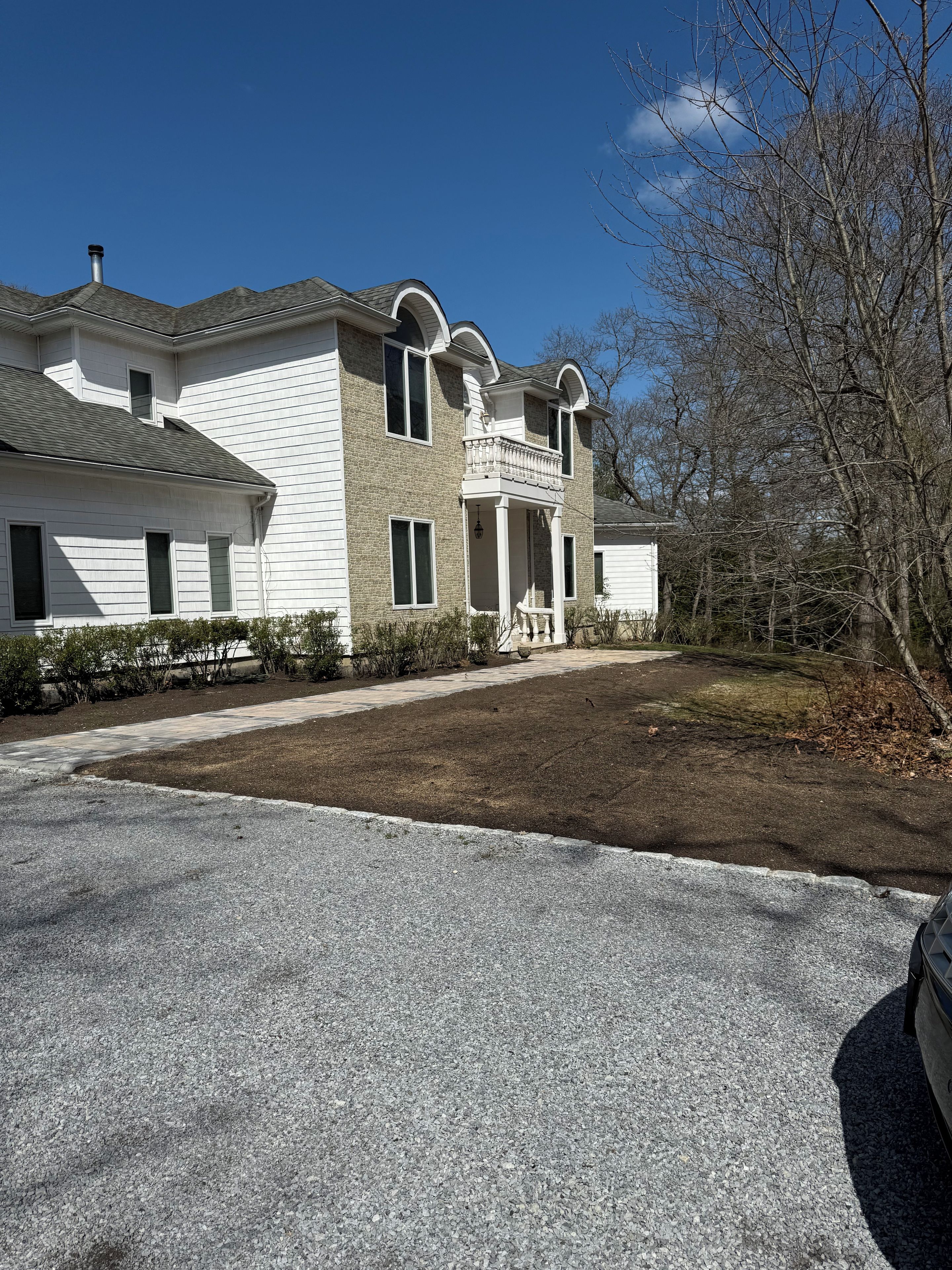 A two-story house with a front porch and a driveway.