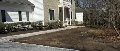 A two-story house with a front porch and a driveway.