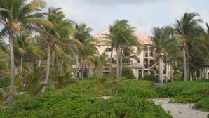 Un resort con diversi edifici, palme e vegetazione lussureggiante.