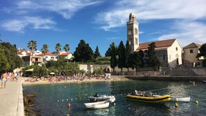 A coastal town with a historic tower, clear blue sky, and calm waters with boats. - Outdoor oasis -apartment, close to center of Hvar (Hvar)