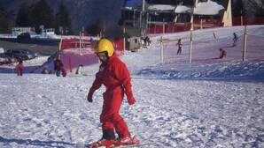 Une piste de ski avec une personne vêtue de rouge qui fait du ski.