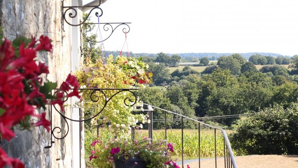 A balcony with hanging plants and a view of a rural landscape. - Charming house with garden, high speed, near Bagnoles de l'Orne (Antoigny)